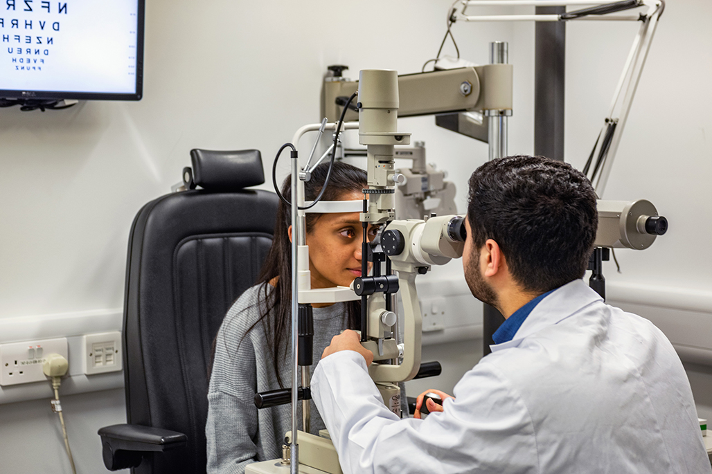 Male student conducting an eye examination 