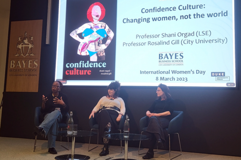 Speakers on stage at the International Women's Day 2023 event on Confidence Culture: Moderator Clarice Metzger, Professor Rosalind Gill, Professor Shani Orgad