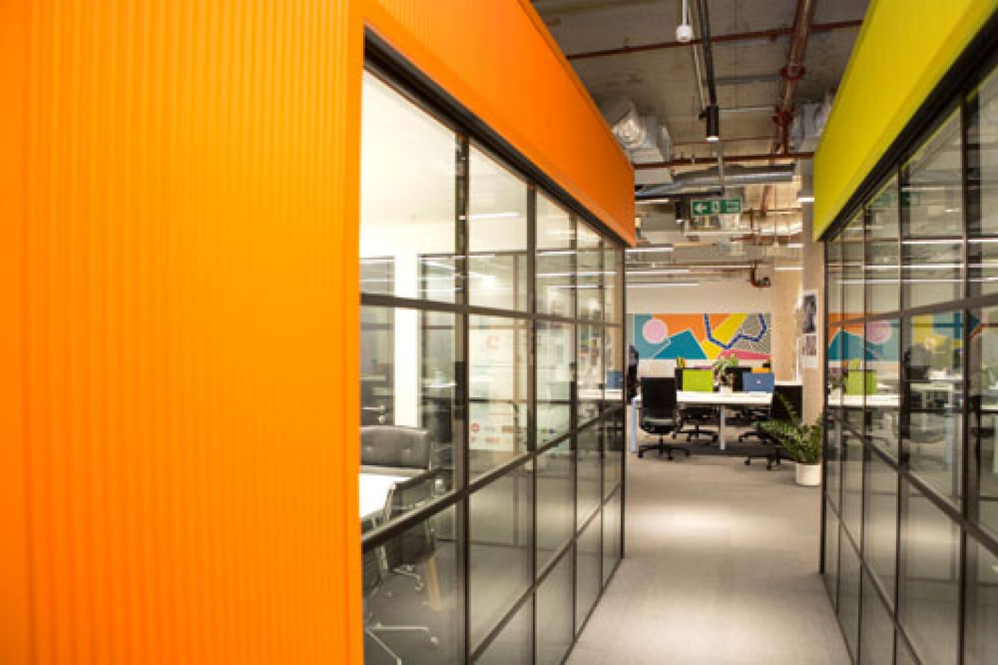 A photo of Better Space with orange walls and glass rooms.