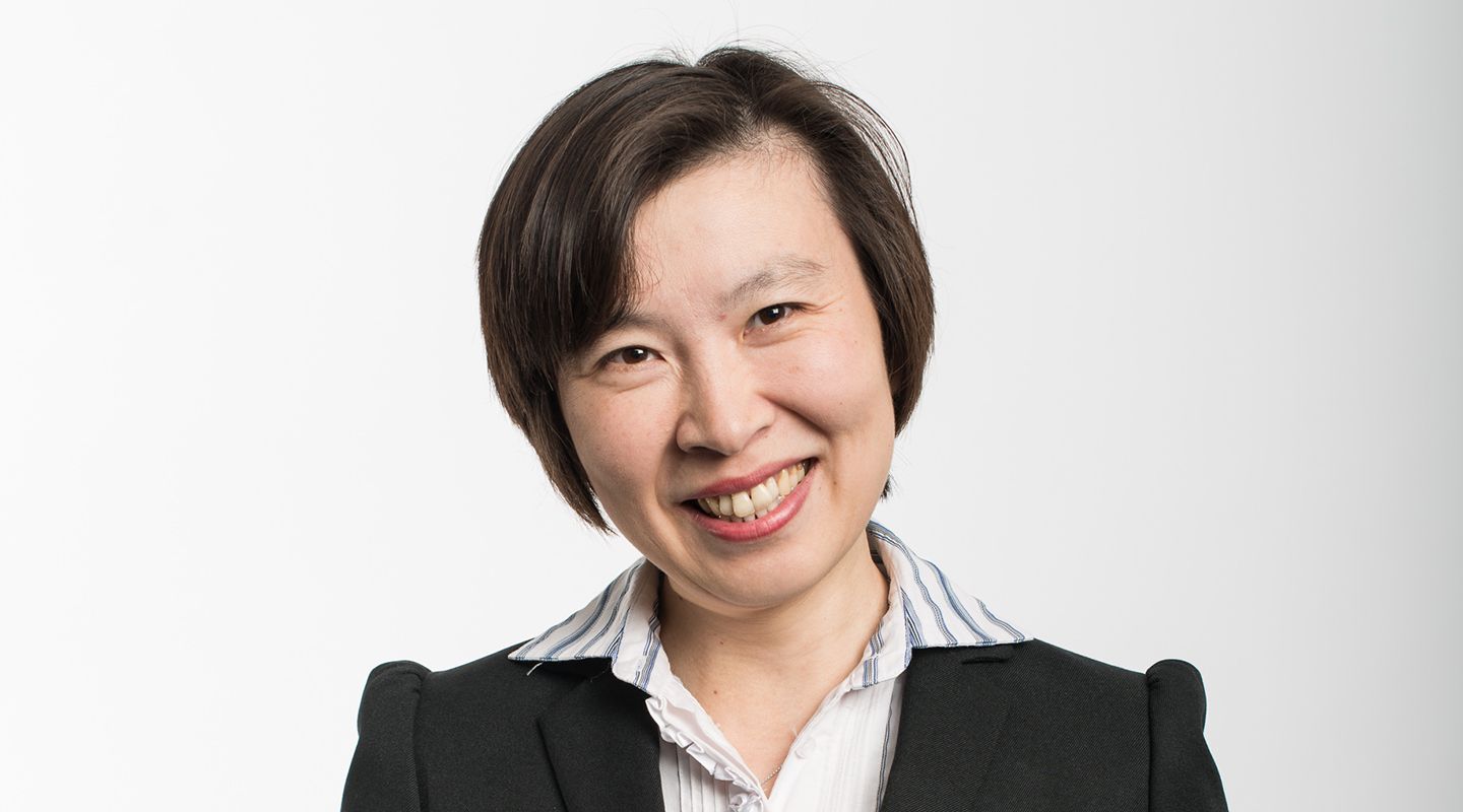 Professor Tong Sun, a smiling East Asian woman with short dark brown and wearing a professional suit.