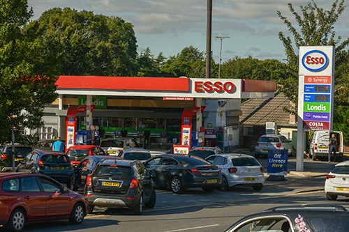 Cars queuing at a petrol station along the road
