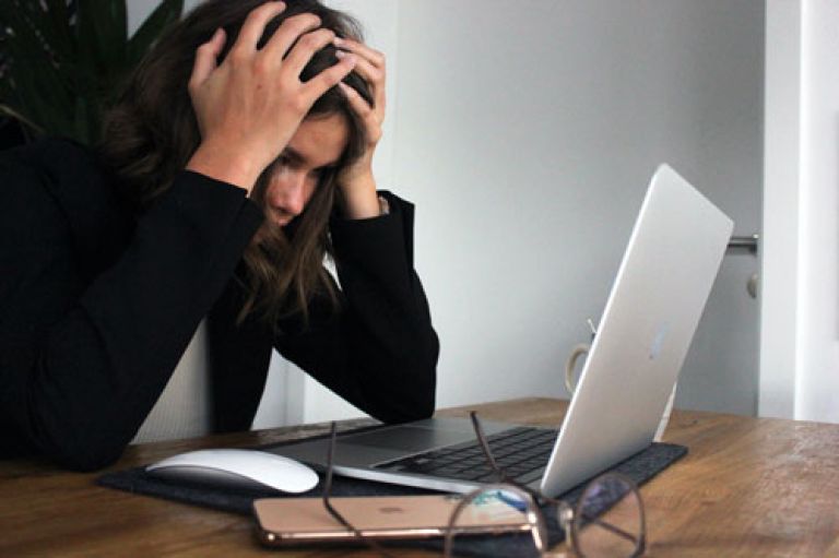 Distressed teenage girl at laptop