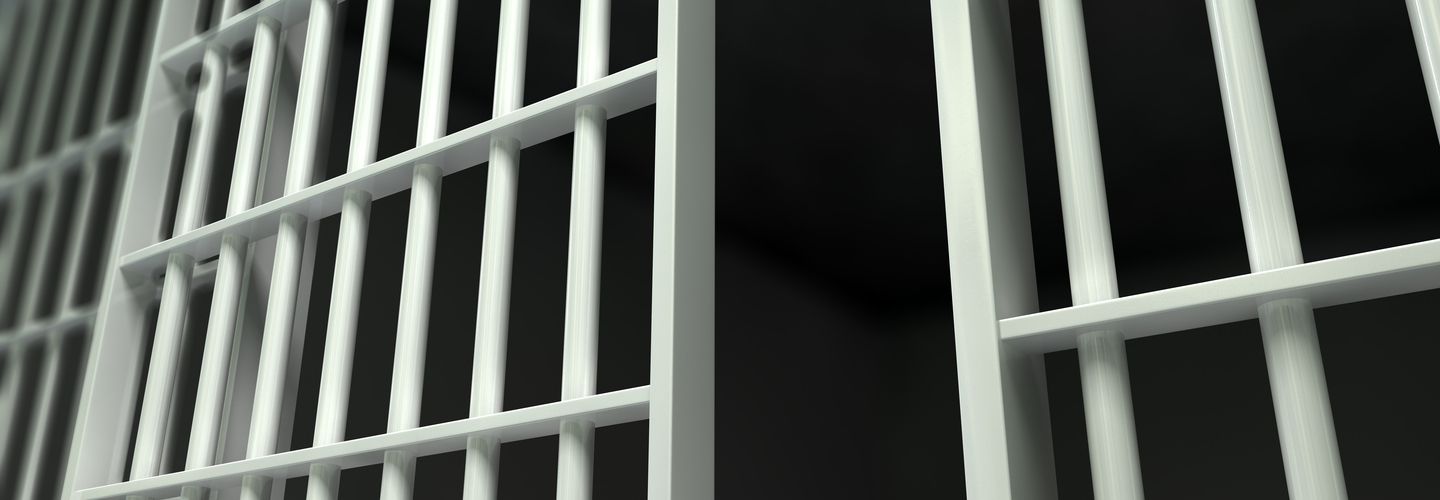 A perspective view of white iron jail cell bars and an open sliding bar door on a dark background