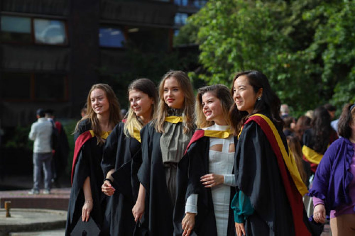Five graduates pose for the camera 