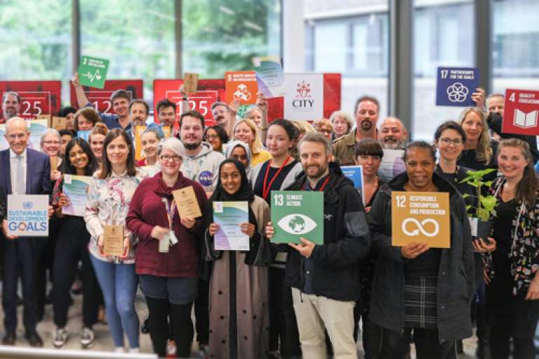 City staff commits commits to the UN Sustainable Development Goals and holds posters with each of the 17 goals