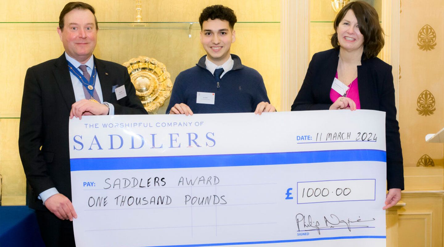 Three people hold up a large cheque