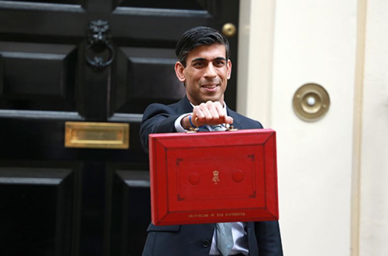 Rishi Sunak stands outside 11 Downing Street holding a red box on Budget Day