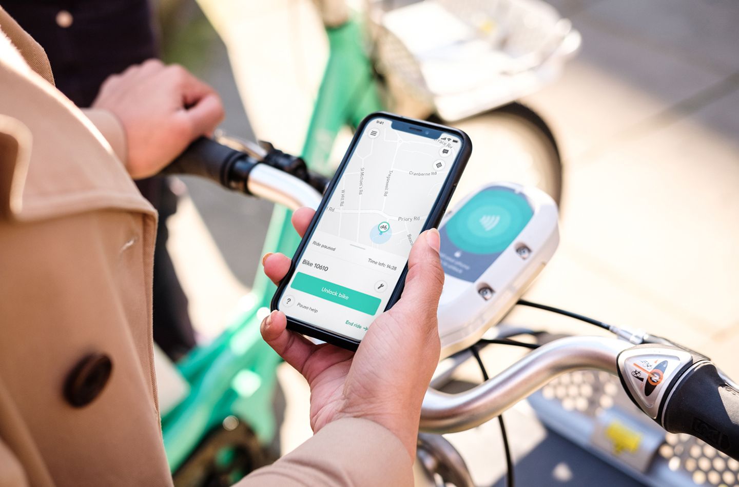 Woman holding her phone looking at beryl bike-share app
