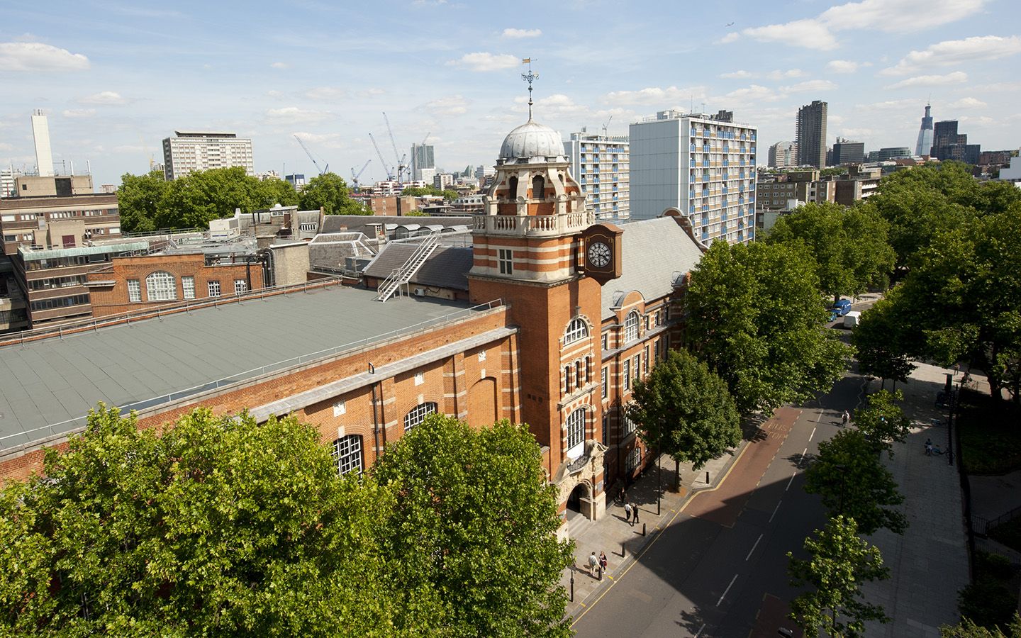 Arial view of the College Building on a sunny day, with the London skyline in the distance.