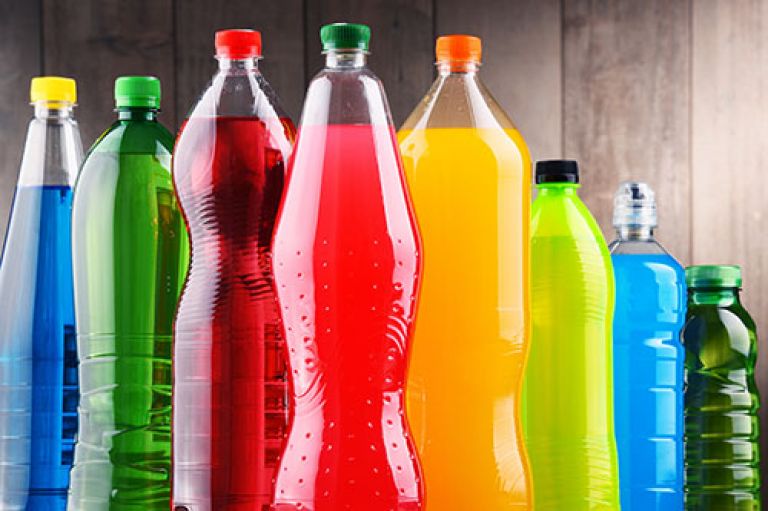Image of sugary drinks bottles against a wooden wall