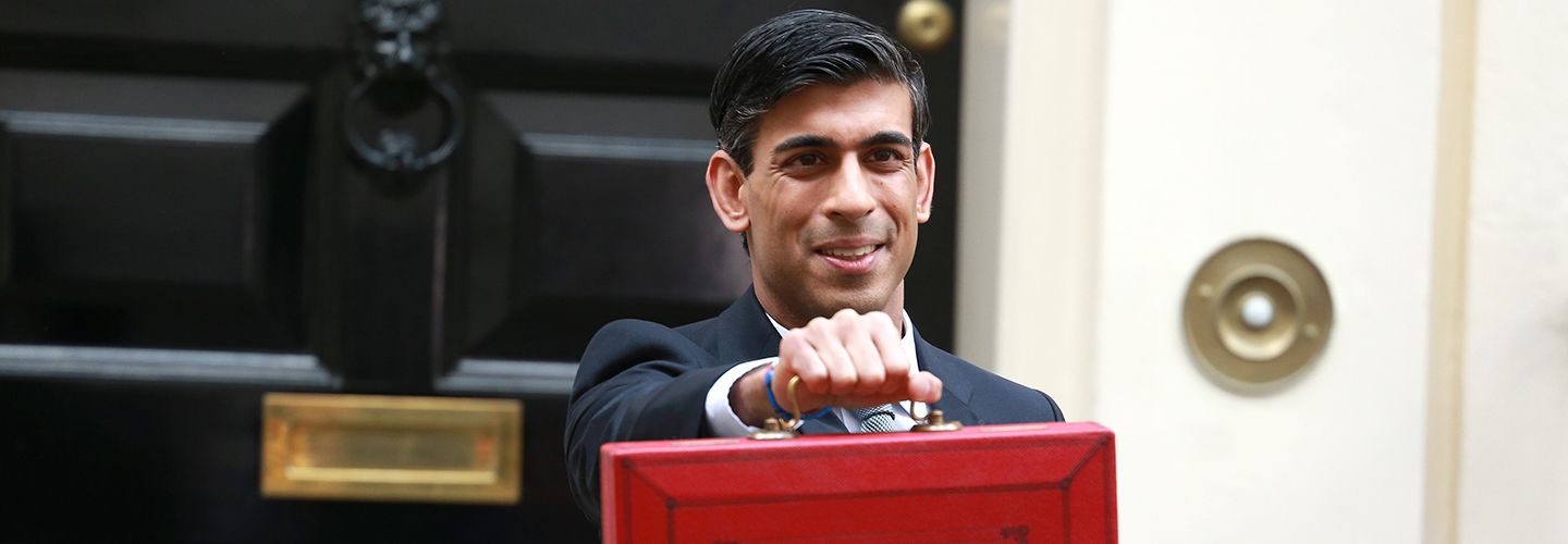 Rishi Sunak stands outside 11 Downing Street holding a red box on Budget Day