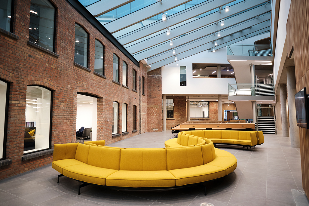 Interior of The City Law School with curved yellow sofa by staircase