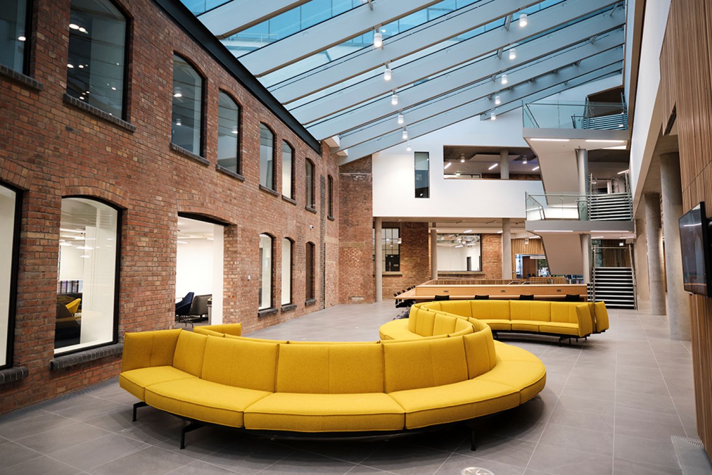 Interior of The City Law School with curved yellow sofa by staircase