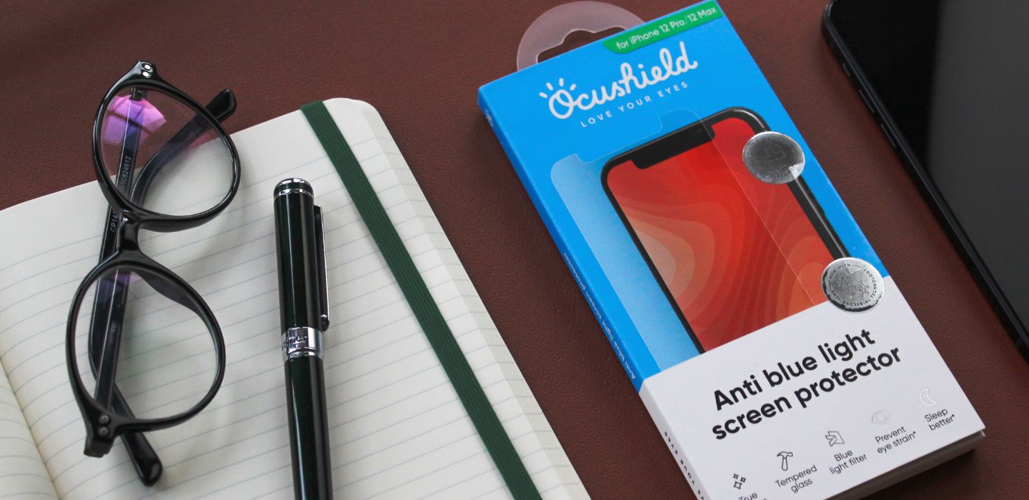 Ocushield anti blue light iphone screen protector packaging next to notepad and glasses