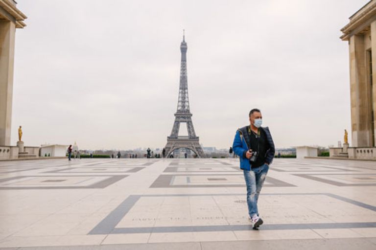 Man walking in Paris wearing facemask
