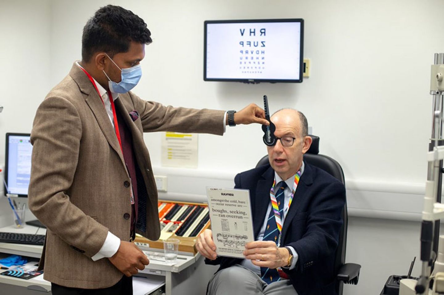 Prof Sir Anthony Finkelstein having his near vision tested with a chart