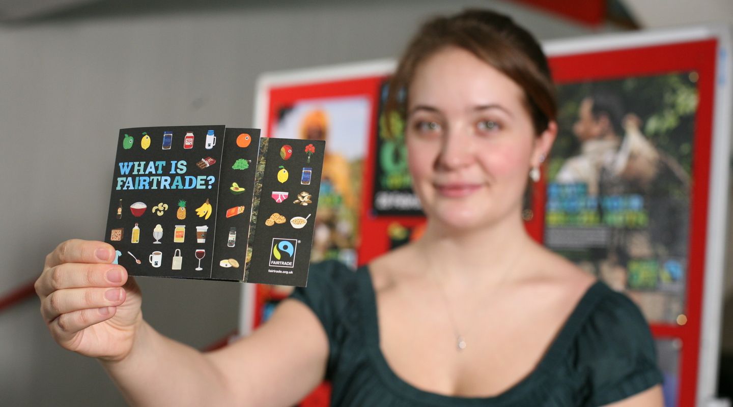 Woman holds up Fairtrade flyer