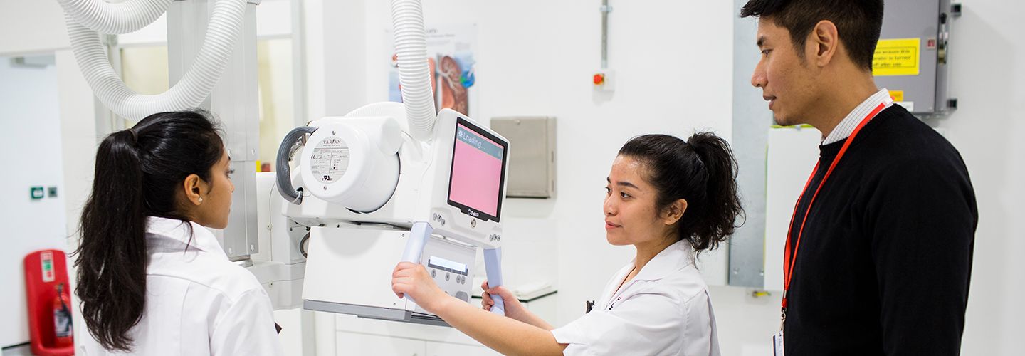 Student radiologists with digital X-Ray machine