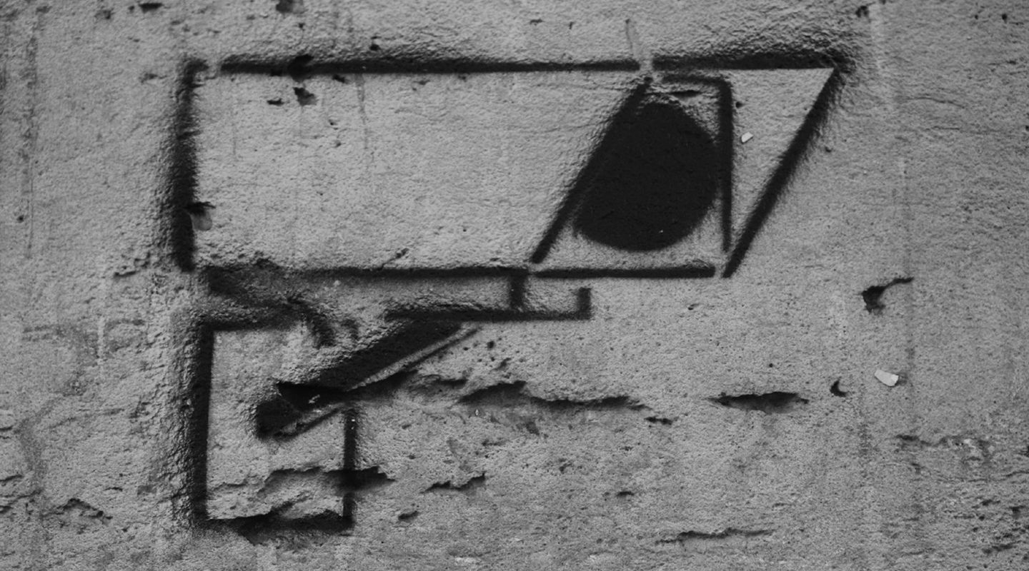 Graffiti of a CCTV camera sprayed on a grey wall.