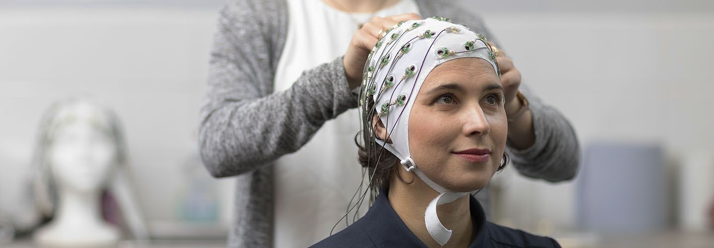 Female patient has a head cap for electroencephalogram (EEG) in psychology lab fitted.
