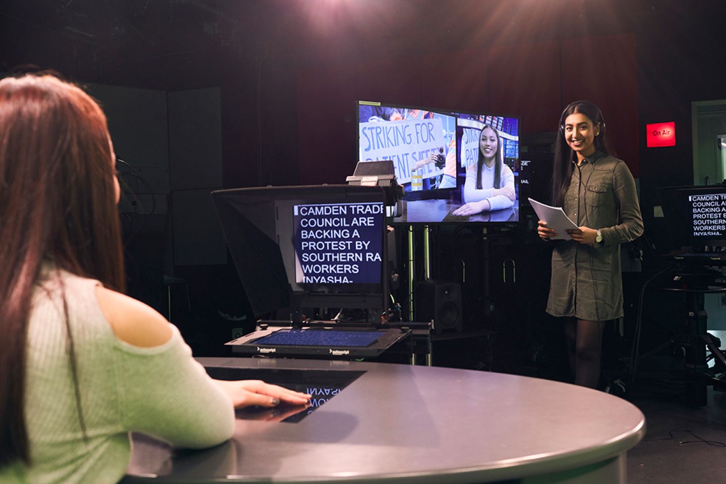 Students presenting and managing the autocue in the journalism TV studio 