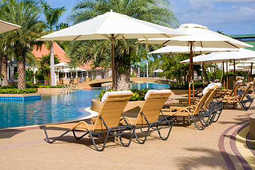 Series of sun loungers in front of a pool at a hotel
