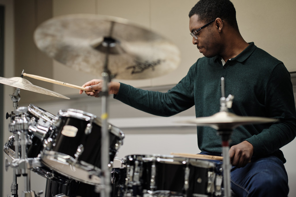 Student drumming in music facilities