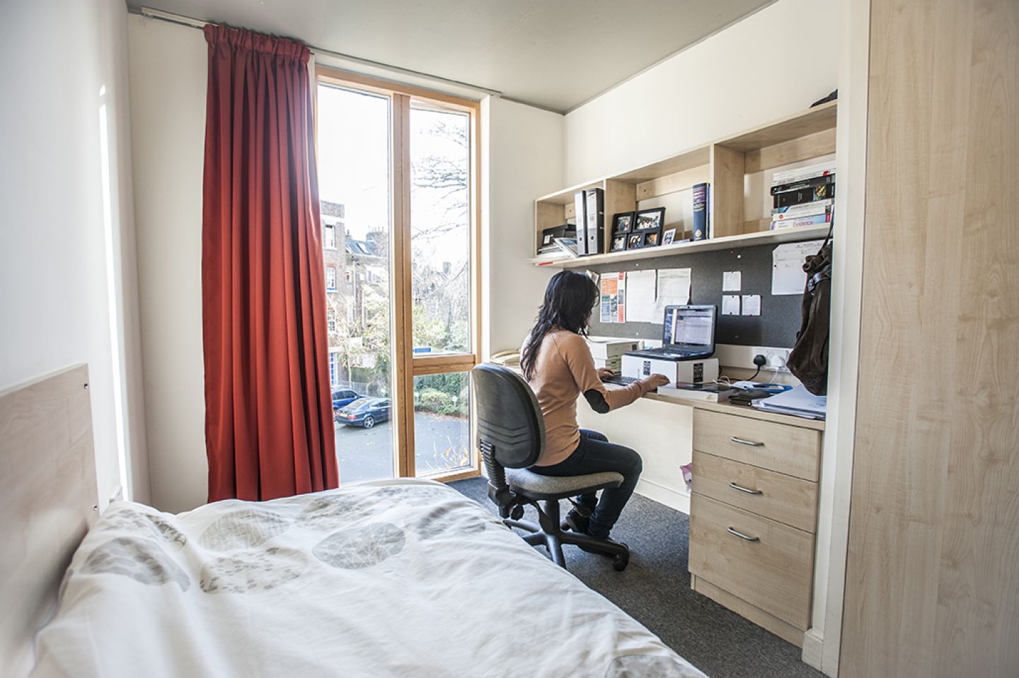 Female student at a desk in bedroom accommodation