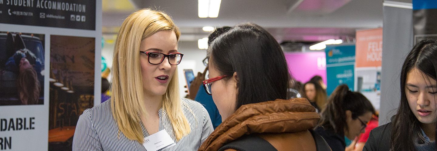 Female accommodation advisor talking to a student at an accommodation fair